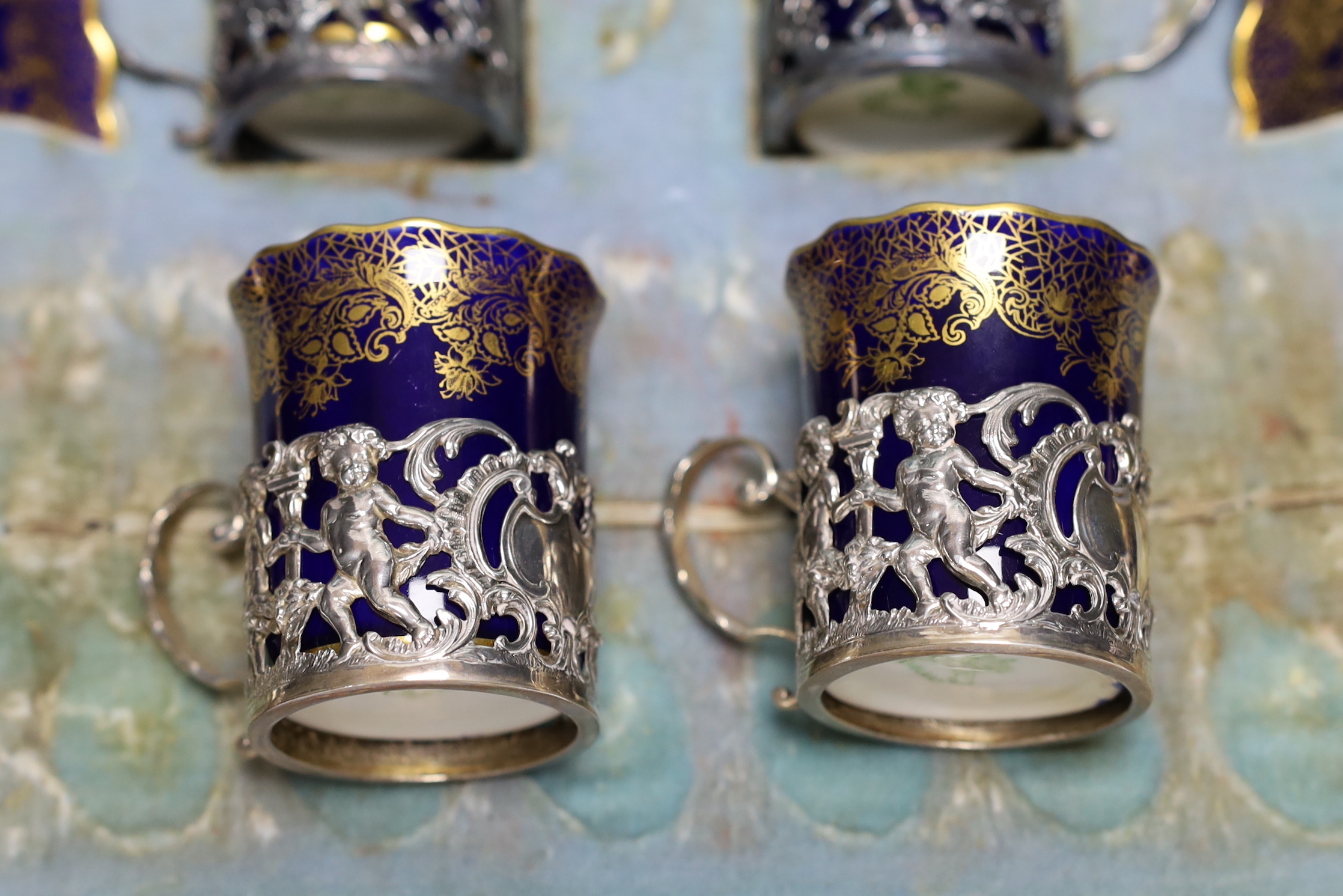 A set of eight Aynsley porcelain coffee cans and saucers, the cans with silver holders, William Hutton & Sons, London, 1905, with fitted case for six (no spoons)